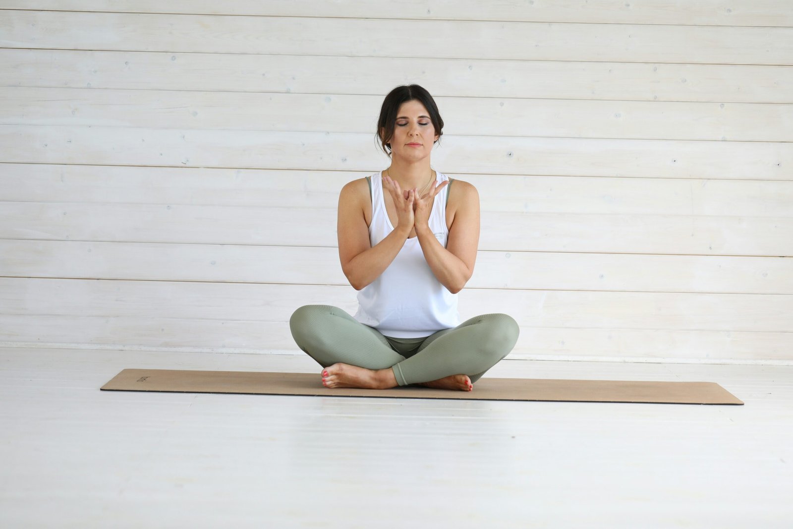 A woman is sitting in a yoga position