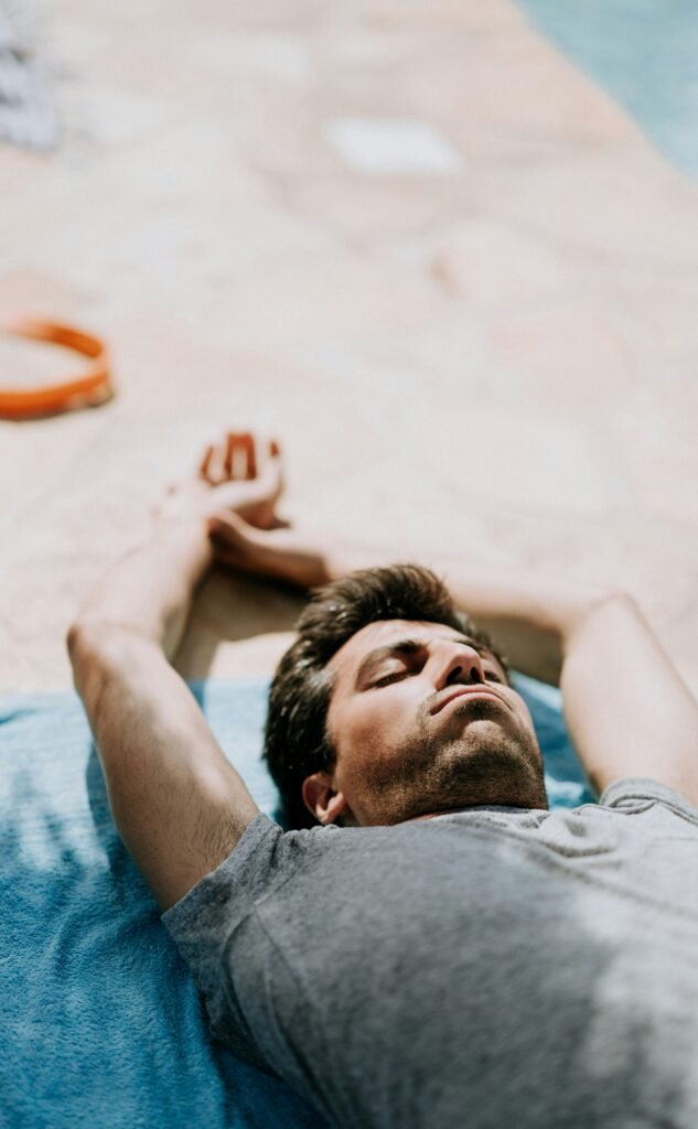 selective focus photography of man lying on blue cushion during daytime selective focus photography of man lying on blue cushion during daytime